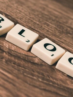 Scrabble tiles spelling 'BLOG' on a wooden background, symbolizing creativity and writing.